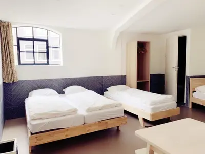 a bedroom with two beds and a table at Hotel The Globe in Amsterdam