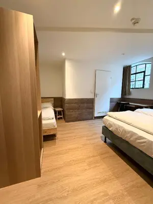 a hotel room with two beds and a desk at Hotel The Globe in Amsterdam