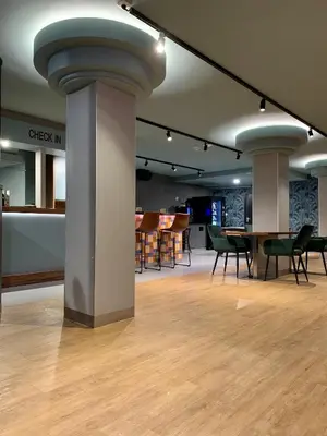 a room with a table and chairs and columns at Hotel The Globe in Amsterdam