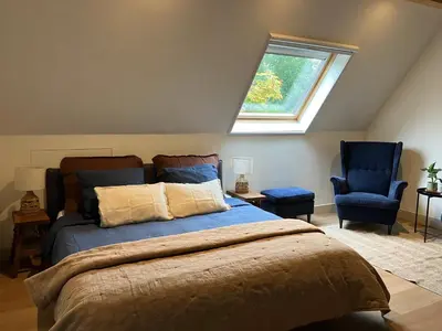 a bedroom with a bed and two blue chairs at Inn Het Nest in Amsterdam