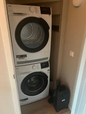 a microwave and a washer and dryer in a room at Parc La Dune Dutch Lodge in Warmenhuizen