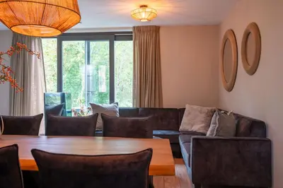 a living room with a table and a couch at Parc La Dune Dutch Lodge in Warmenhuizen