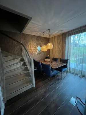 a dining room with a table and chairs and a staircase at Parc La Dune Marrakesh Lodge in Warmenhuizen