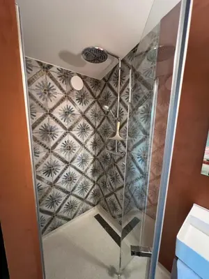 a shower in a bathroom with a tiled wall at Parc La Dune Marrakesh Lodge in Warmenhuizen