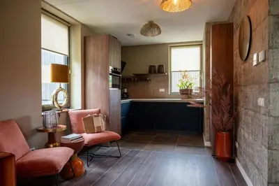 a living room with a couch and a chair and a kitchen at Parc La Dune Marrakesh Lodge in Warmenhuizen