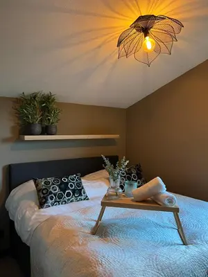 a bedroom with a bed with a table on it at Parc La Dune South Africa Lodge in Warmenhuizen