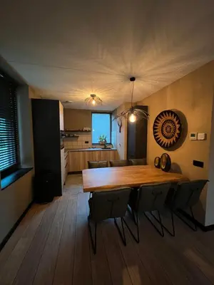a dining room and kitchen with a wooden table and chairs at Parc La Dune South Africa Lodge in Warmenhuizen