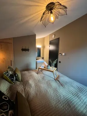 a bedroom with a large bed with a table on it at Parc La Dune South Africa Lodge in Warmenhuizen