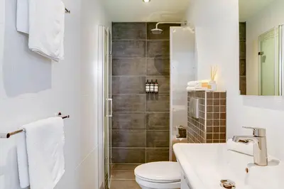 a bathroom with a shower and a toilet and a sink at Haarlem Hotel Suites in Haarlem