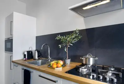 a kitchen with a sink and a counter with fruit on it at Haarlem Hotel Suites in Haarlem