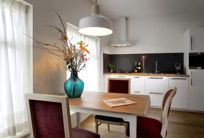 a kitchen with a table and a vase with flowers on it at Haarlem Hotel Suites in Haarlem