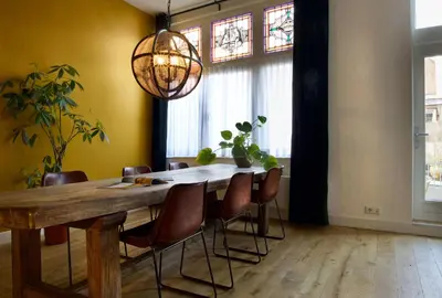 a dining room with a wooden table and chairs at Haarlem Hotel Suites in Haarlem
