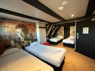 a bedroom with two beds and a brick wall at Heart of Amsterdam Hostel in Amsterdam