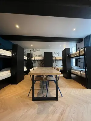 a room with a table and two bunk beds at Heart of Amsterdam Hostel in Amsterdam