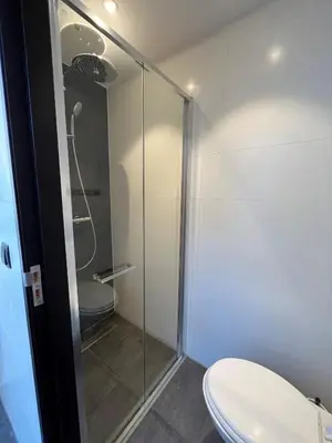 a bathroom with a toilet and a glass shower at Heart of Amsterdam Hostel in Amsterdam