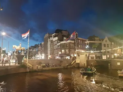 a group of people in a boat on a river at night at EUPHRATE HOUSeBOAT in Amsterdam