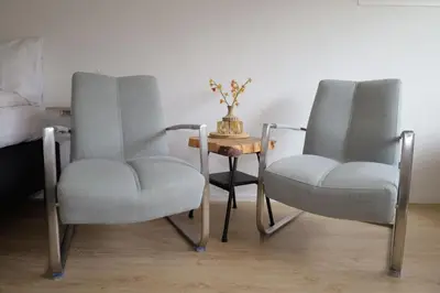 two chairs and a table with a vase on it at De Blokhut in Egmond aan den Hoef