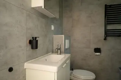 a bathroom with a white sink and a toilet at De Blokhut in Egmond aan den Hoef