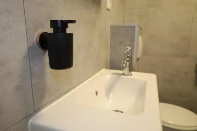 a white sink in a bathroom with a toilet at De Blokhut in Egmond aan den Hoef