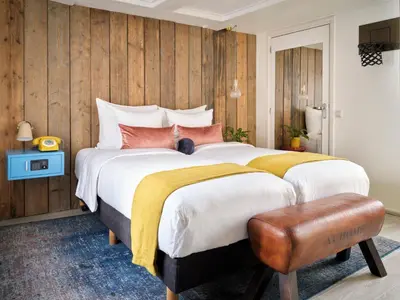 a bedroom with a large bed with wooden walls at Max Brown Hotel Canal District, part of Sircle Collection in Amsterdam