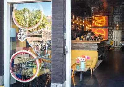 a window of a store with a bike on the wall at Max Brown Hotel Canal District, part of Sircle Collection in Amsterdam
