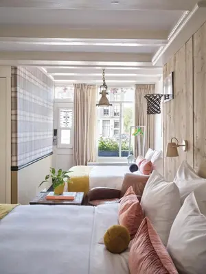 a hotel room with two beds with pillows at Max Brown Hotel Canal District, part of Sircle Collection in Amsterdam