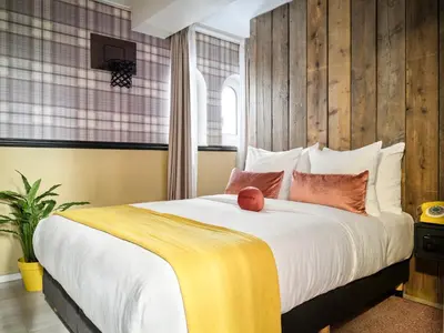 a bedroom with a large white bed with pillows at Max Brown Hotel Canal District, part of Sircle Collection in Amsterdam