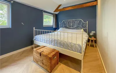 a bedroom with a bed and a blue wall at Lovely Home In Putten With Kitchen in Putten
