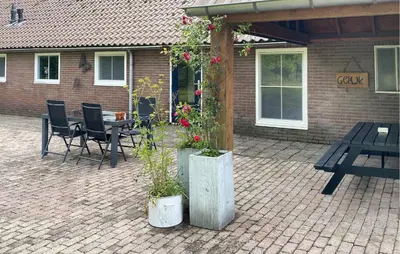 a patio with a table and a bench and flowers at Lovely Home In Putten With Kitchen in Putten