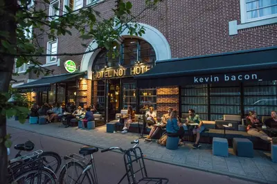 a group of people sitting outside of a book store at Hotel Not Hotel Amsterdam in Amsterdam