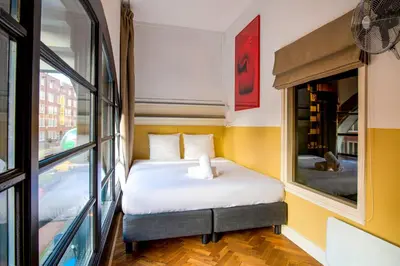 a small bed in a room with a window at Hotel Not Hotel Amsterdam in Amsterdam