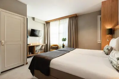 a hotel room with a bed and a window at The Delphi - Amsterdam Townhouse in Amsterdam