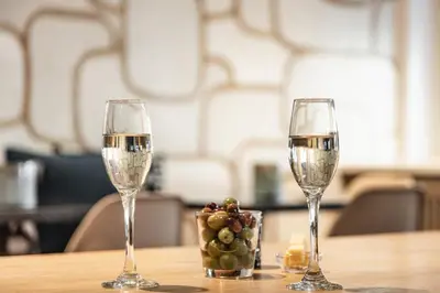 two glasses of wine and a basket of grapes on a table at The Delphi - Amsterdam Townhouse in Amsterdam