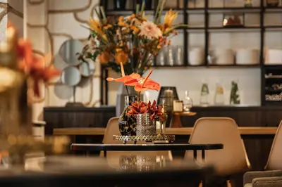 a table with a vase of flowers on it at The Delphi - Amsterdam Townhouse in Amsterdam