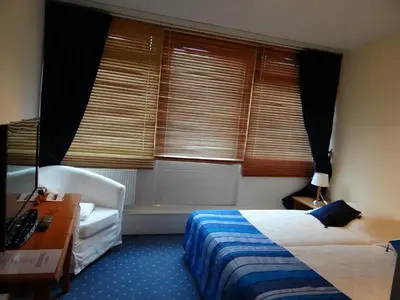 a bedroom with a bed and a desk and a window at The Waverly House in Ouderkerk aan de Amstel