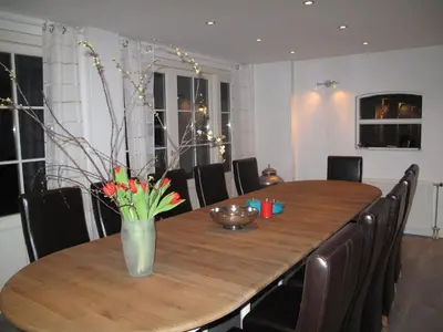 a dining room table with a vase of flowers on it at The Waverly House in Ouderkerk aan de Amstel