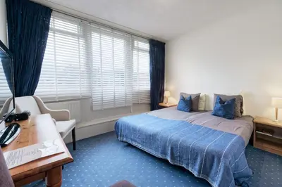 a hotel room with a bed and a desk and window at The Waverly House in Ouderkerk aan de Amstel