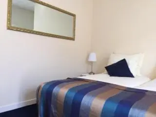 a bedroom with a bed with a mirror on the wall at The Waverly House in Ouderkerk aan de Amstel