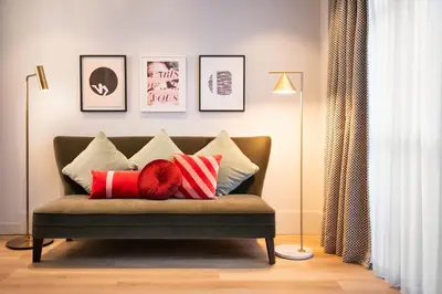 a couch with pillows on it in a living room at Maison ELLE Amsterdam in Amsterdam