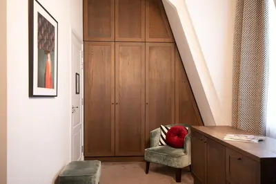 a room with a staircase with a chair and a cabinet at Maison ELLE Amsterdam in Amsterdam