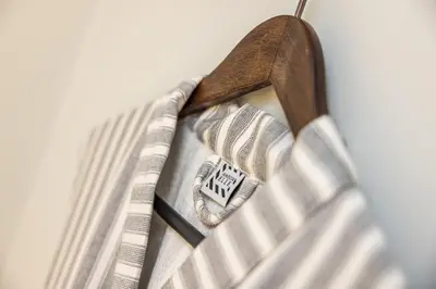 a tie hanging from a wooden hanger at Maison ELLE Amsterdam in Amsterdam
