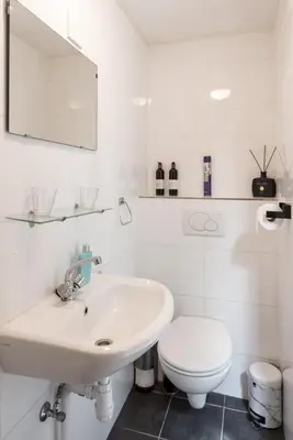 a white bathroom with a sink and a toilet at Gezellig appartement in de mooie oude binnenstad van Alkmaar in Alkmaar