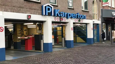 a parking lot with a pka proton sign on a building at Gezellig appartement in de mooie oude binnenstad van Alkmaar in Alkmaar
