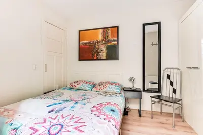 a bedroom with a bed and a mirror at Gezellig appartement in de mooie oude binnenstad van Alkmaar in Alkmaar