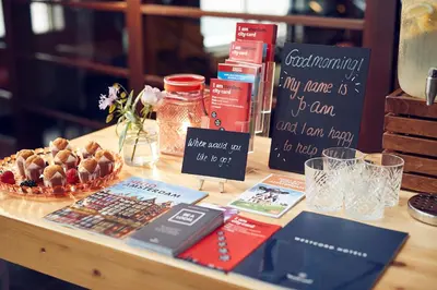 a table with books and a basket of food on it at WestCord Art Hotel Amsterdam 4 stars in Amsterdam