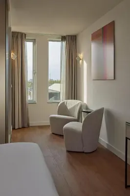 a hotel room with two chairs and a bed at WestCord Art Hotel Amsterdam 4 stars in Amsterdam
