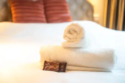 a pile of towels sitting on top of a bed at Renovated Parkside Gem - 2 person studio in the Pijp in Amsterdam