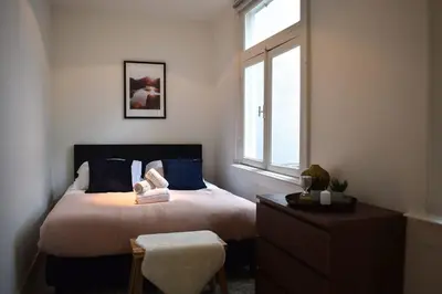 a bedroom with a bed with blue pillows and a window at Rembrandtplein house A in Amsterdam