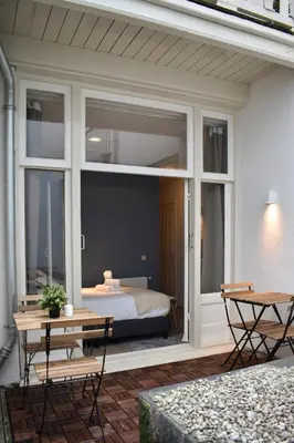 a patio with a bed in a room with windows at Rembrandtplein house A in Amsterdam
