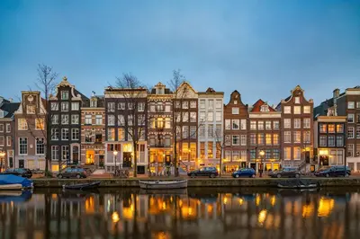 a group of buildings next to a river with boats at Ambassade Hotel in Amsterdam